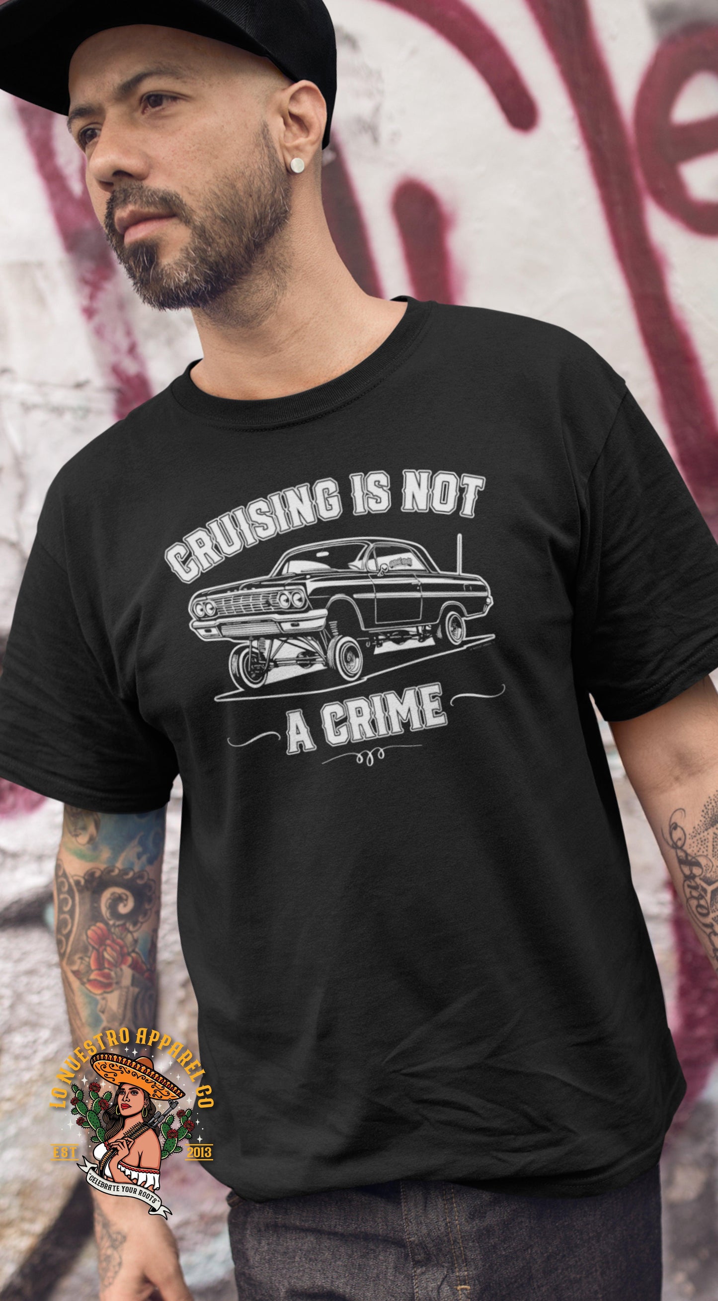 Man wearing the 'Cruising Is Not a Crime' T-Shirt, perfect for representing Chicano pride and lowrider culture.