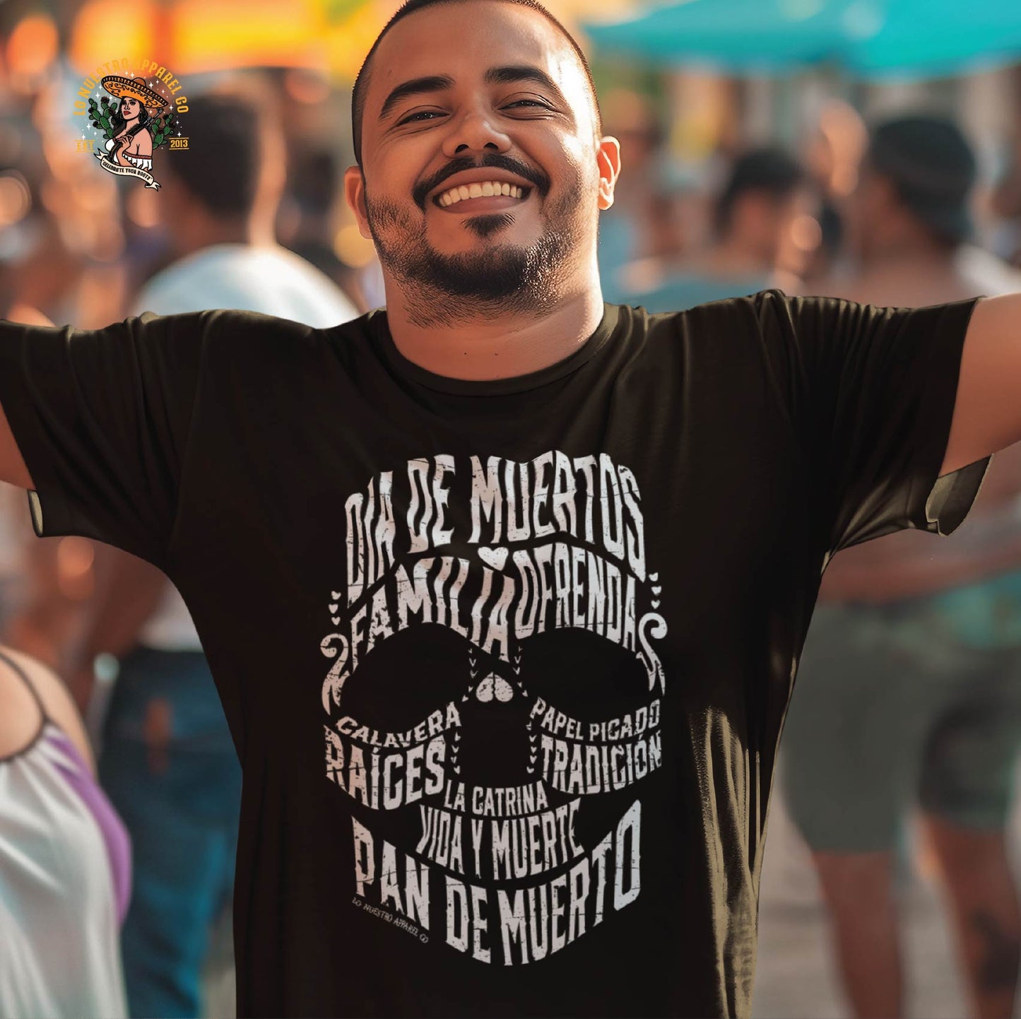 Man wearing a Dia de los Muertos shirt at a lively celebration, featuring a calligram skull design that represents the tradition of Day of the Dead shirts.