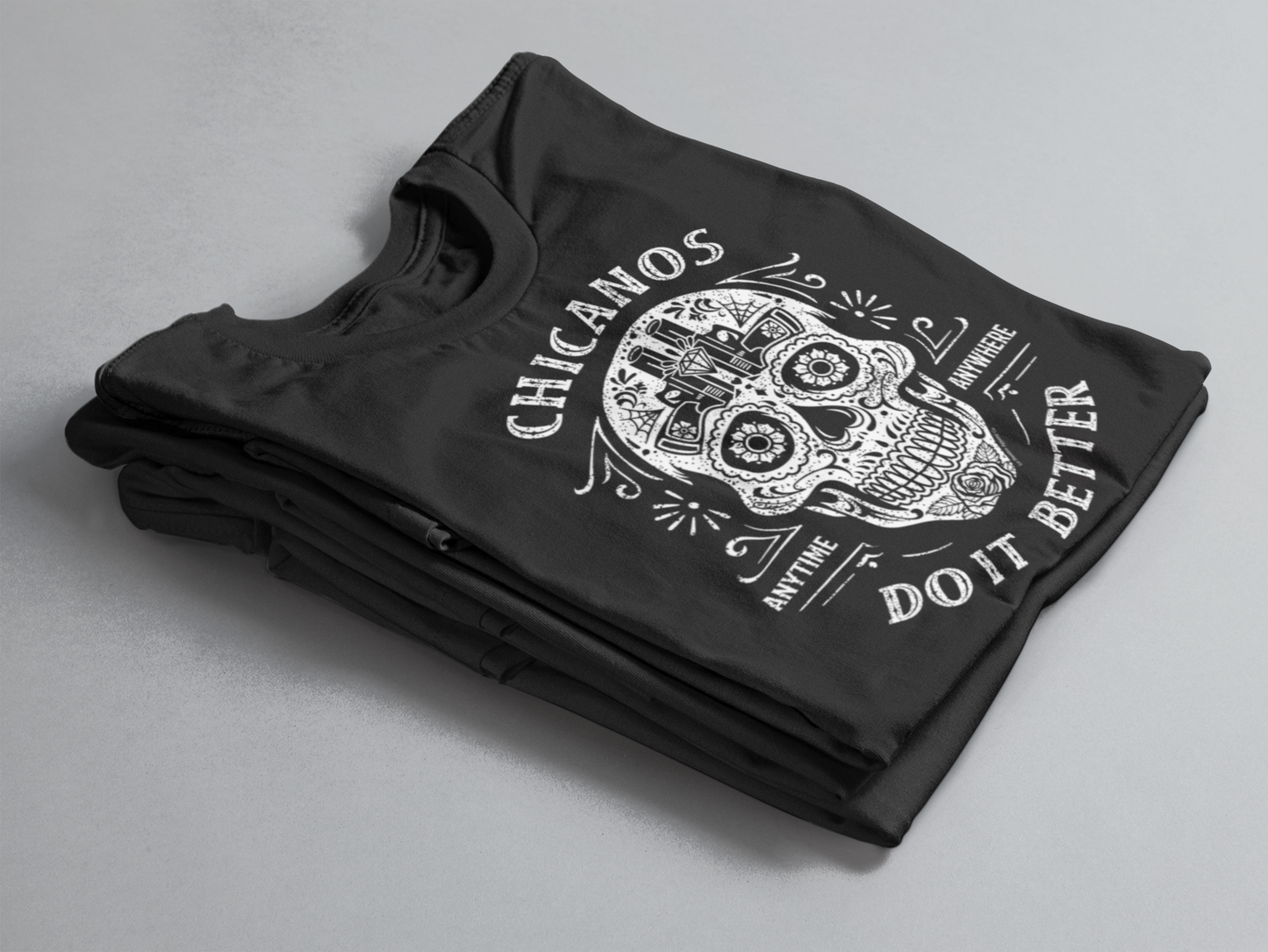 Close-up of the graphic on the "Chicanos Do It Better" T-shirt showing detailed sugar skull artwork.