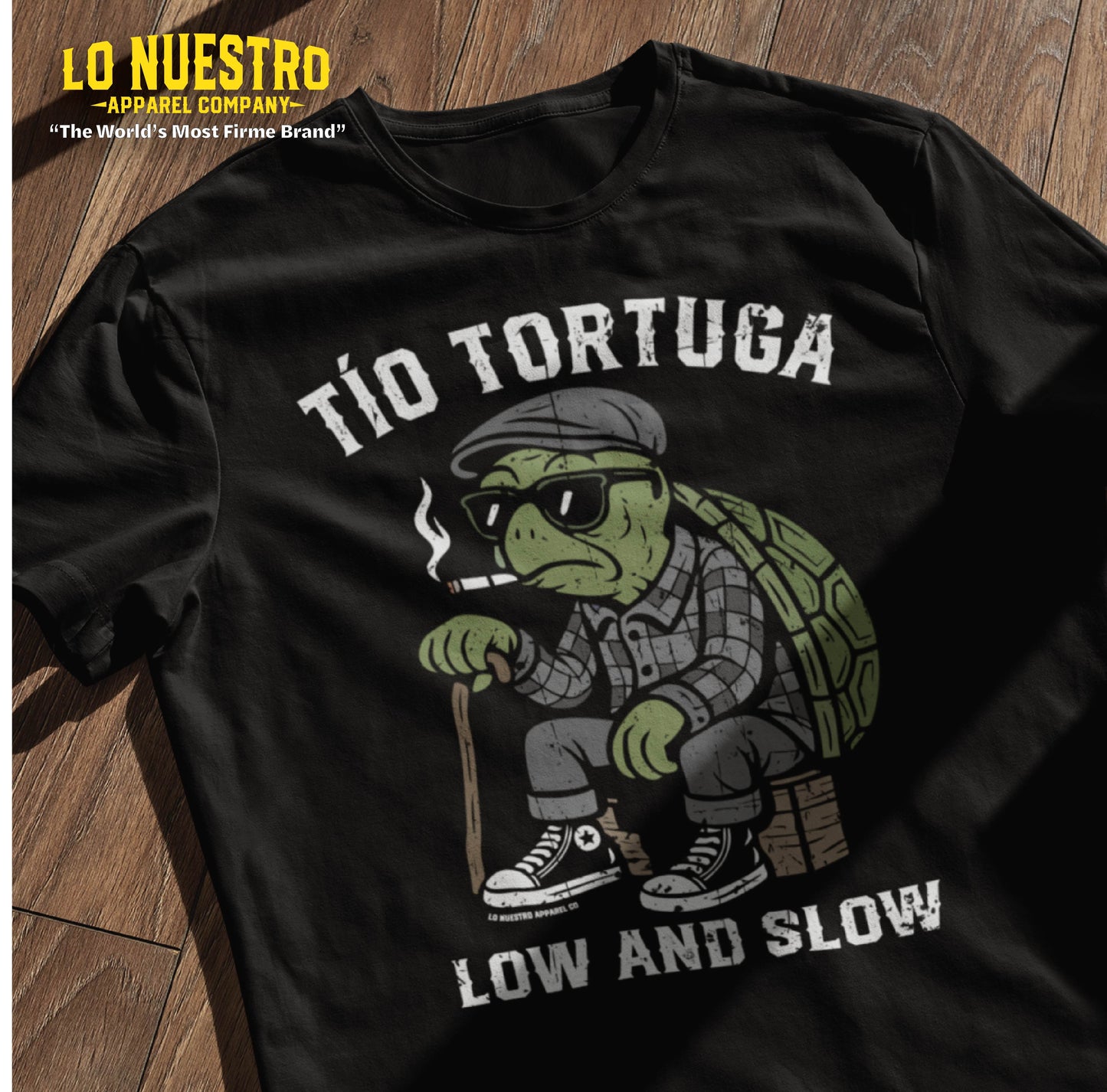 Flat lay of a black Tio Tortuga funny Mexican shirt featuring a cartoon turtle in Chicano clothing, printed with "Low and Slow" text.
