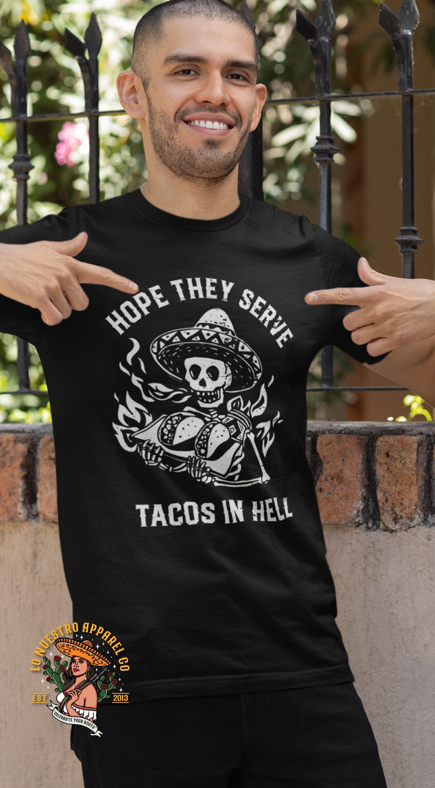 Man wearing "Hope They Serve Tacos in Hell" t-shirt, a funny taco lover shirt featuring a skull holding tacos with flames in the background. This black cotton tee is perfect for Mexican food lovers and fans of humorous streetwear.