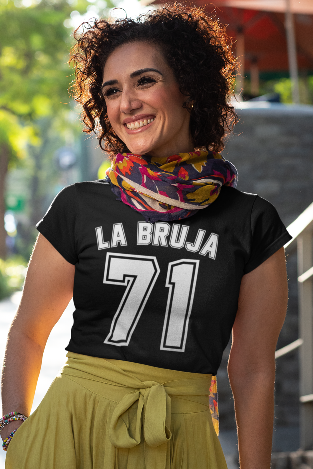 A woman wearing a black "La Bruja 71" t-shirt, inspired by the classic El Chavo del 8 character. Perfect for fans of Mexican TV nostalgia.