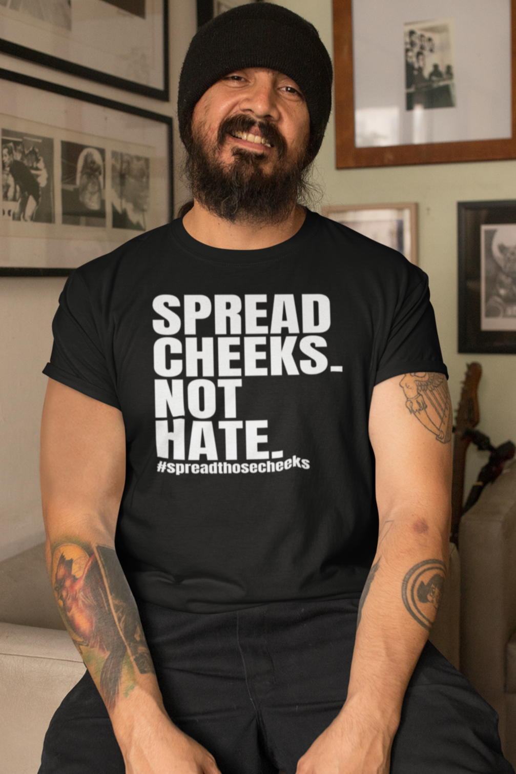 Man wearing black "Spread Cheeks Not Hate" T-shirt with bold white text. Funny statement tee for casual streetwear.
