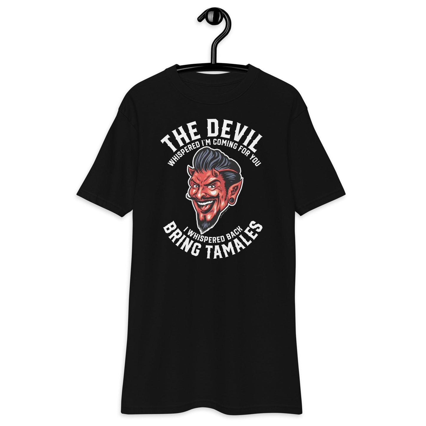 Black t-shirt with a devil illustration and the phrase 'The Devil Whispered I'm Coming For You. I Whispered Back Bring Tamales.' displayed on a hanger.