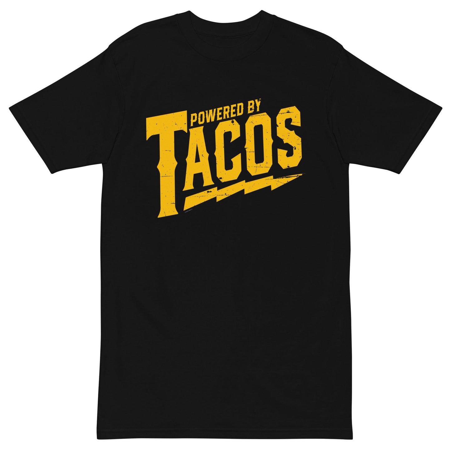 Flat-lay of a black 'Powered by Tacos' t-shirt with yellow distressed lettering and lightning bolts.