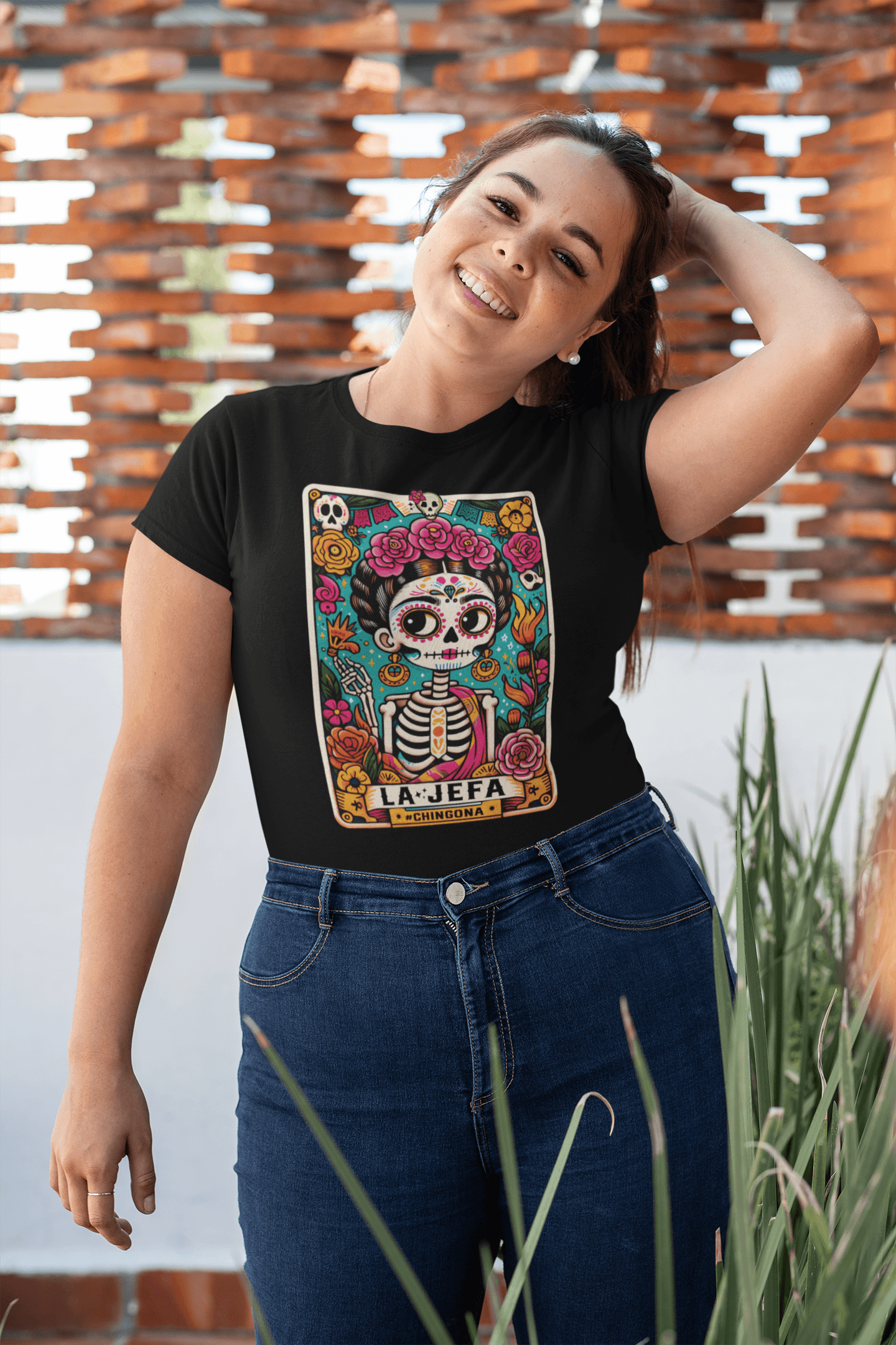 A woman proudly wearing a black relaxed t-shirt with a bold 'La Jefa' tarot card design, showcasing her strength and style.