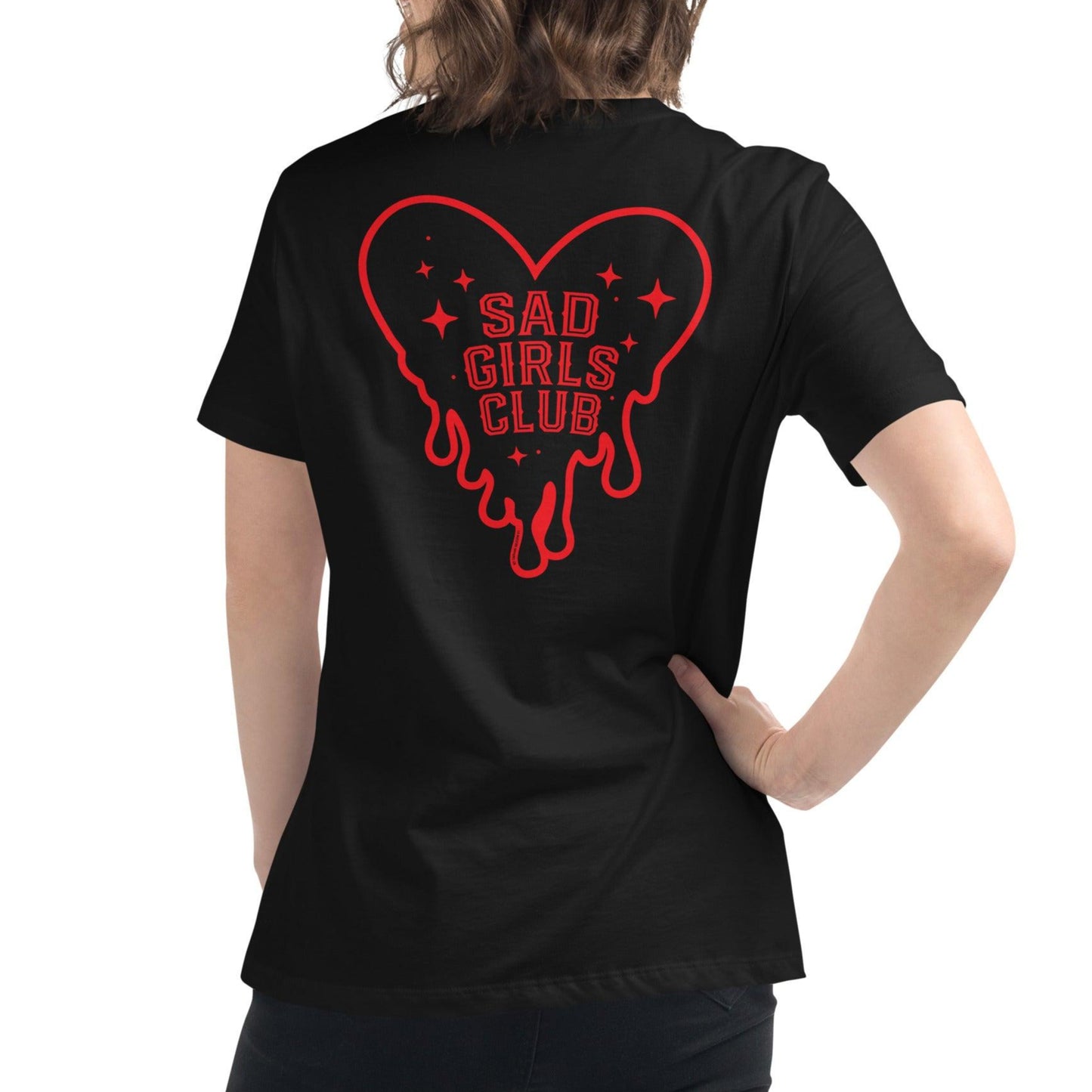 Woman wearing a black t-shirt featuring a red melting heart with stars and "Sad Girls Club" back print, blending alternative and retro streetwear.
