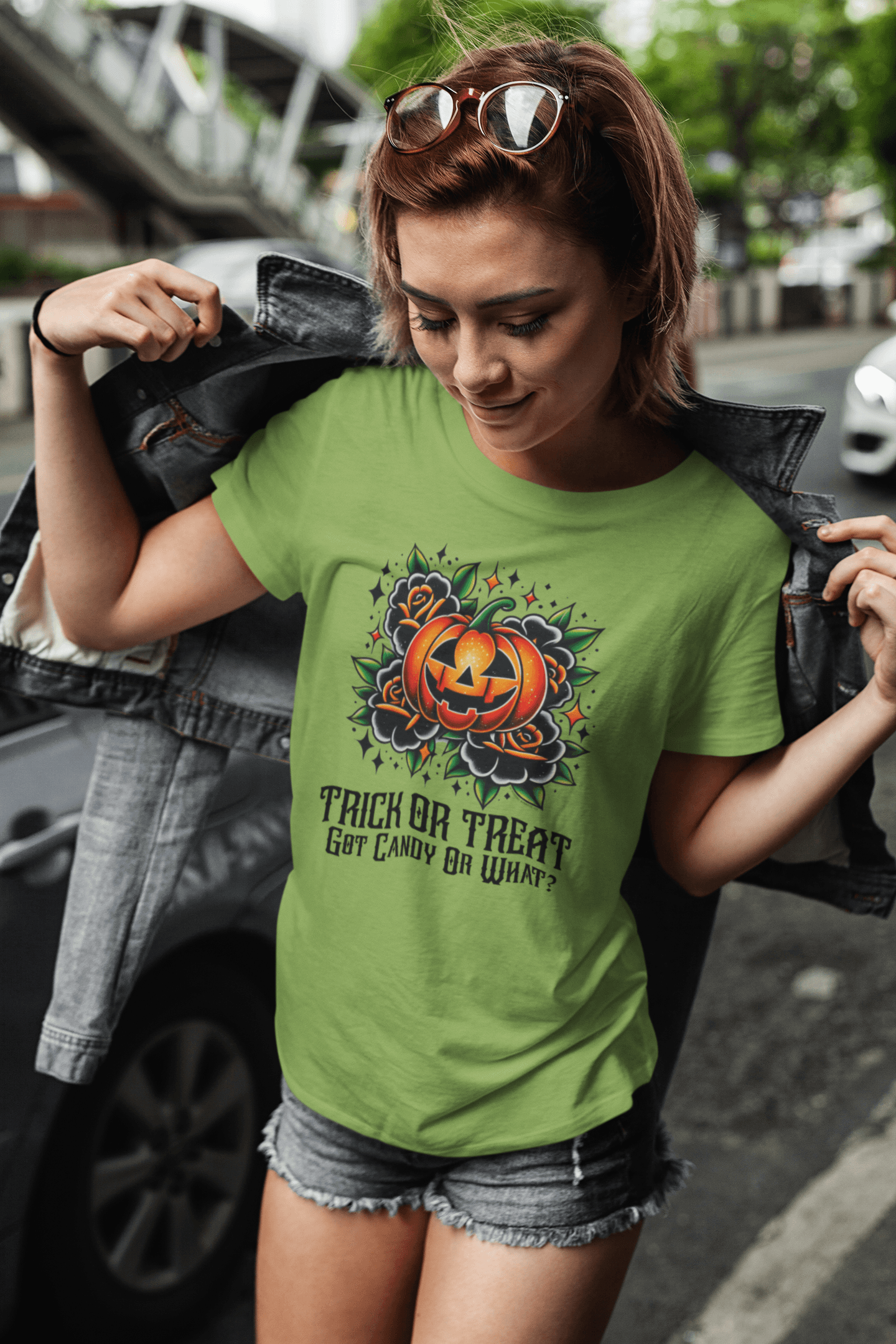 Woman wearing a Leaf Green 'Trick or Treat, Got Candy Or What?' t-shirt, walking confidently down a city street.