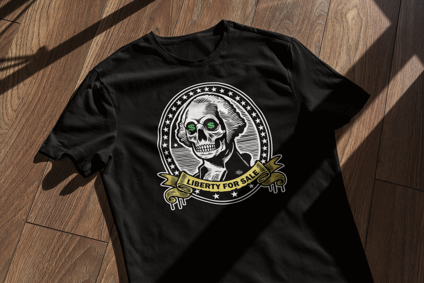 "Flat lay of the 'Liberty for Sale' t-shirt on a wooden surface, featuring a skeletal George Washington with dollar signs in his eyes and a 'Liberty for Sale' banner."