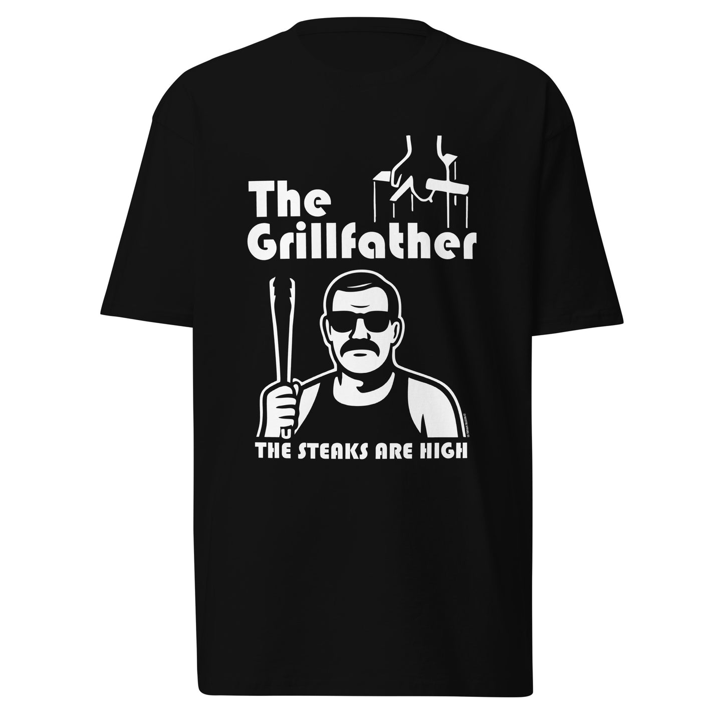 Black t-shirt laid flat on white background featuring The Grillfather design with puppet strings, a cholo-style character holding tongs, and the phrase The Steaks Are High.