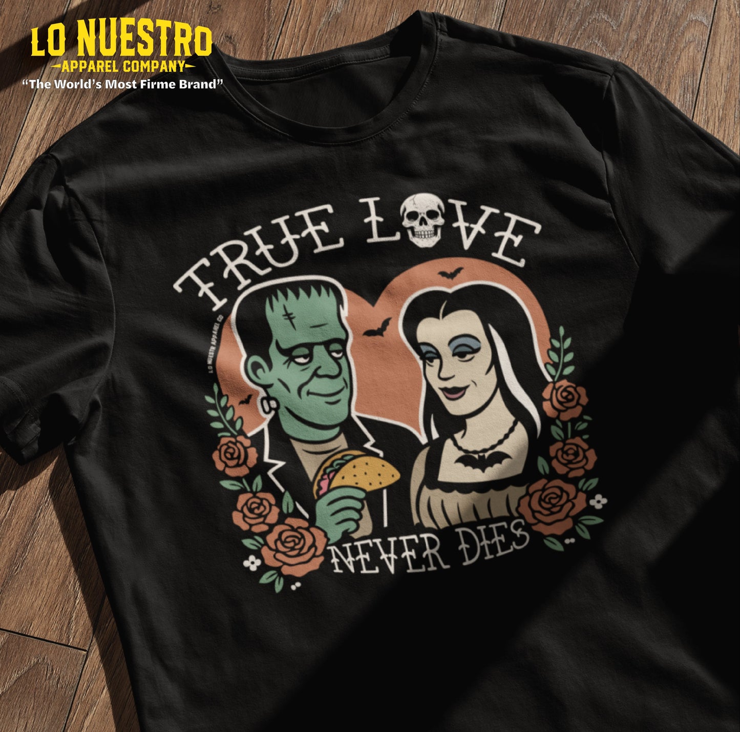 Flatlay of black Halloween t-shirt with spooky couple and taco design, a funny Mexican shirt for all seasons.