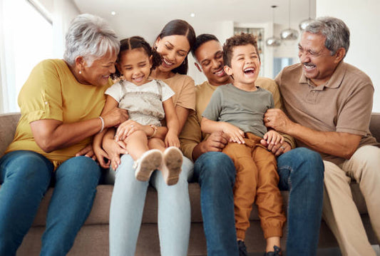 Three generations of a Chicano family sitting together, sharing laughter and embracing their heritage.