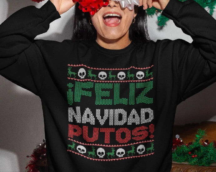 Flat lay of a "Feliz Navidad Putos" unisex sweatshirt surrounded by holiday decorations, showcasing the festive and humorous design.
