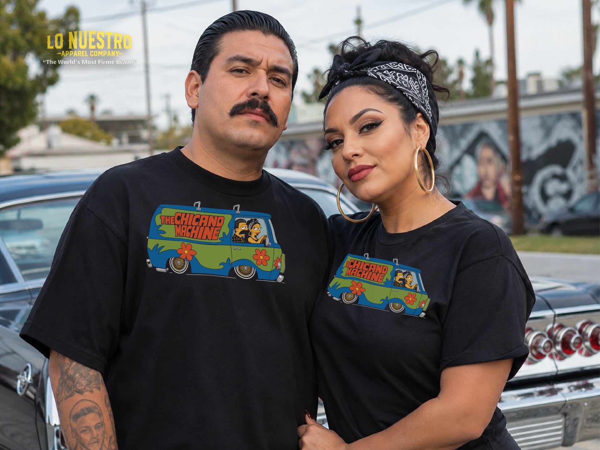 Photo of a Latino couple wearing black Chicano Machine T-shirts in a Southern California street setting.