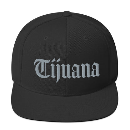 Black snapback hat with "Tijuana" text in old English embroidery, adjustable fit, perfect for showcasing cultural pride.