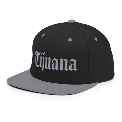 Black and Silver snapback hat with "Tijuana" text in old English embroidery, adjustable fit, adding a bold touch to urban streetwear.