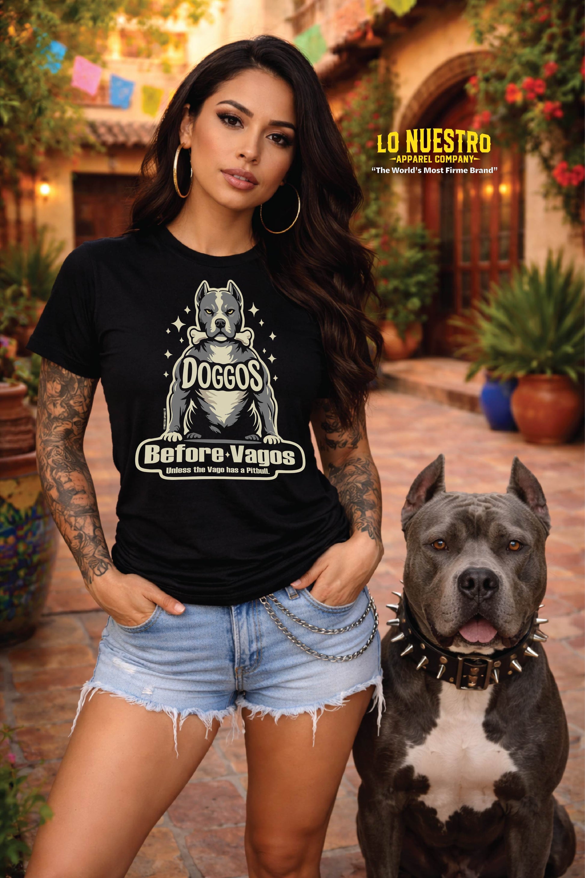Hispanic woman wearing Doggos Before Vagos t-shirt standing with pitbull in Mexican courtyard