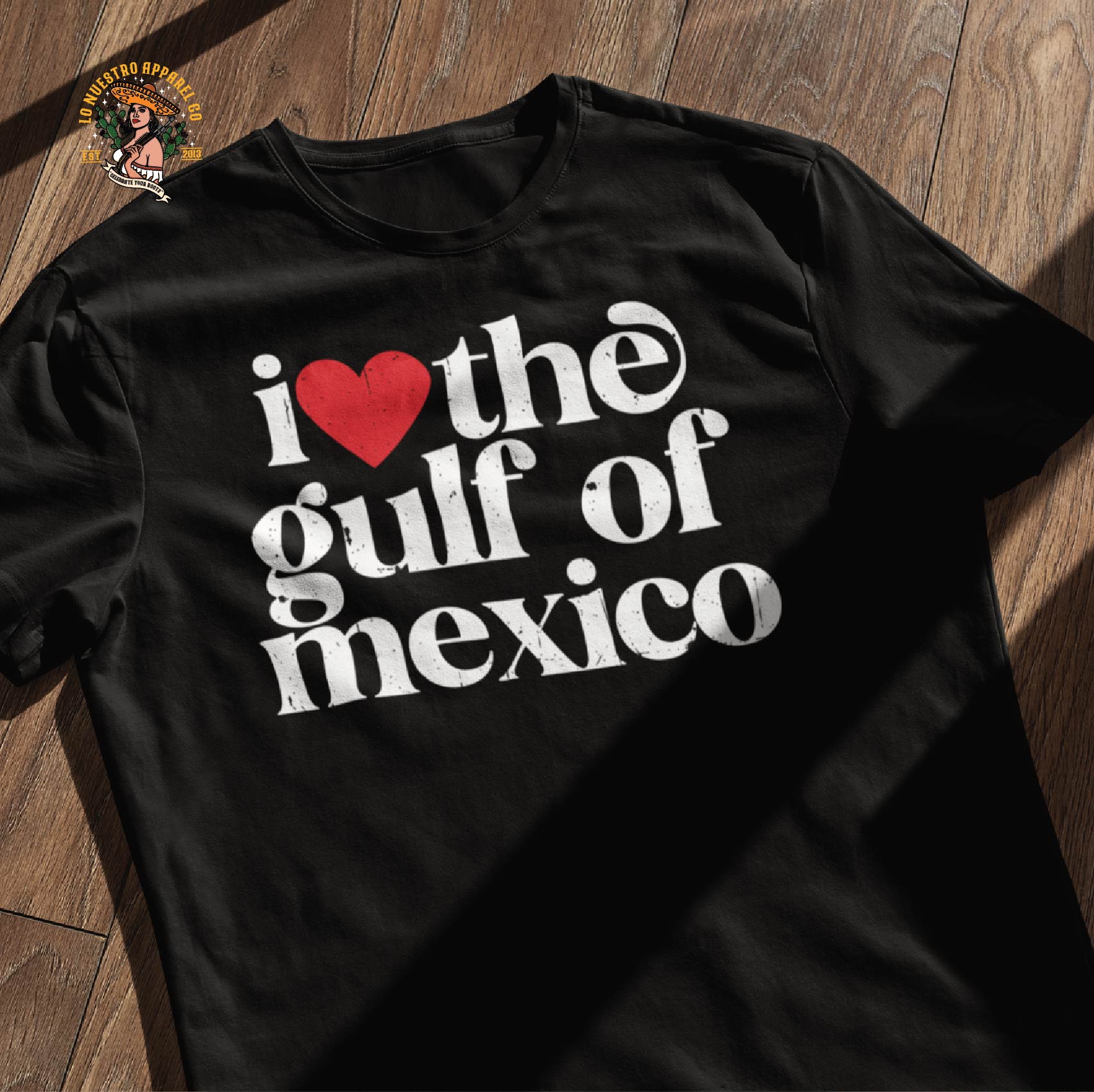 The I Love The Gulf Of Mexico on a wooden floor. Part of our Funny Shirts and funny Mexico shirts line of premium men's shirts. Mexican Pride Shirts line.