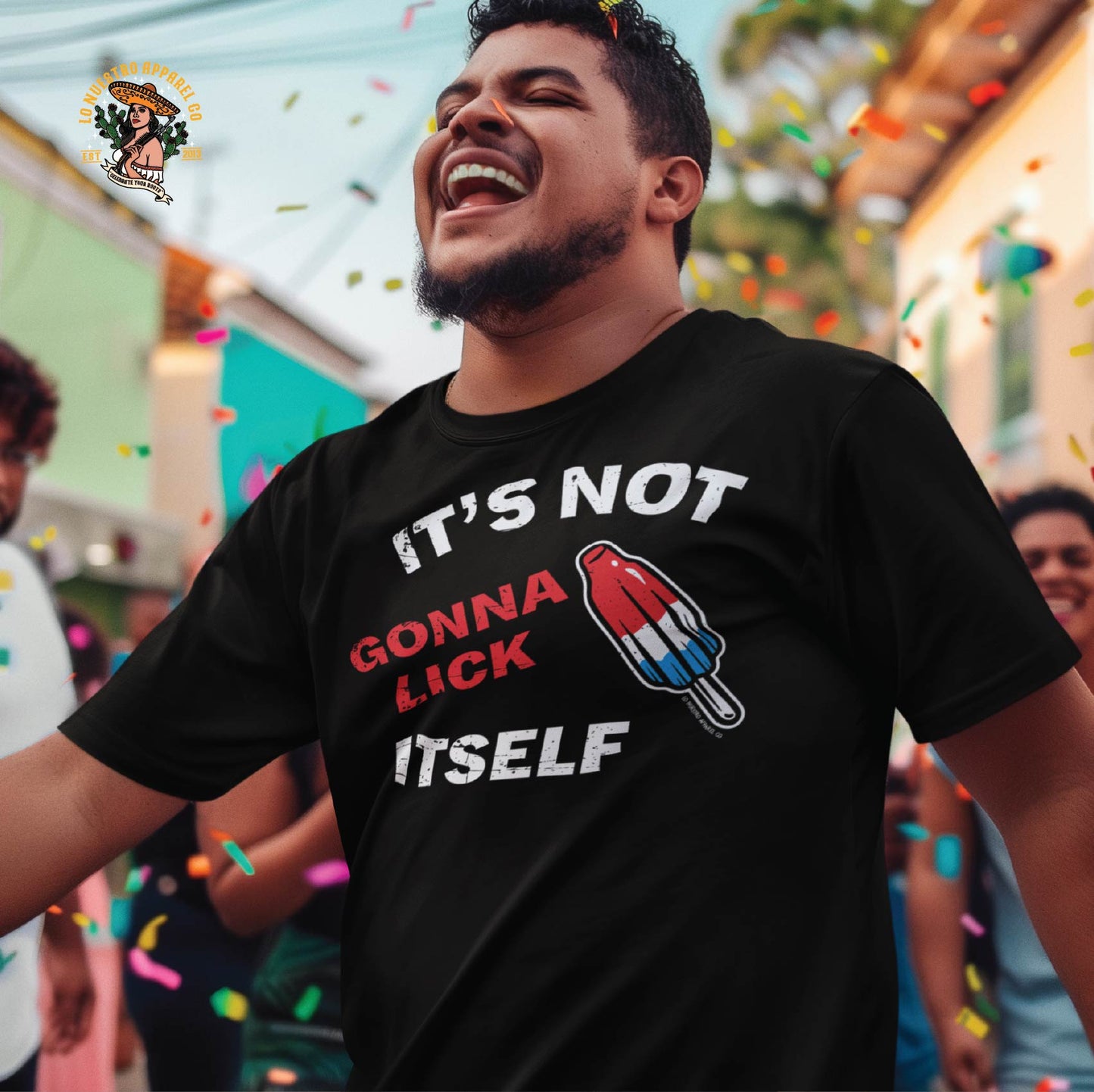 A Hispanic male model wearing a black It's Not Going To Lick Itself distressed tshirt while laughing at an outdoor festival. Part of our Funny Shirts for Men collection.