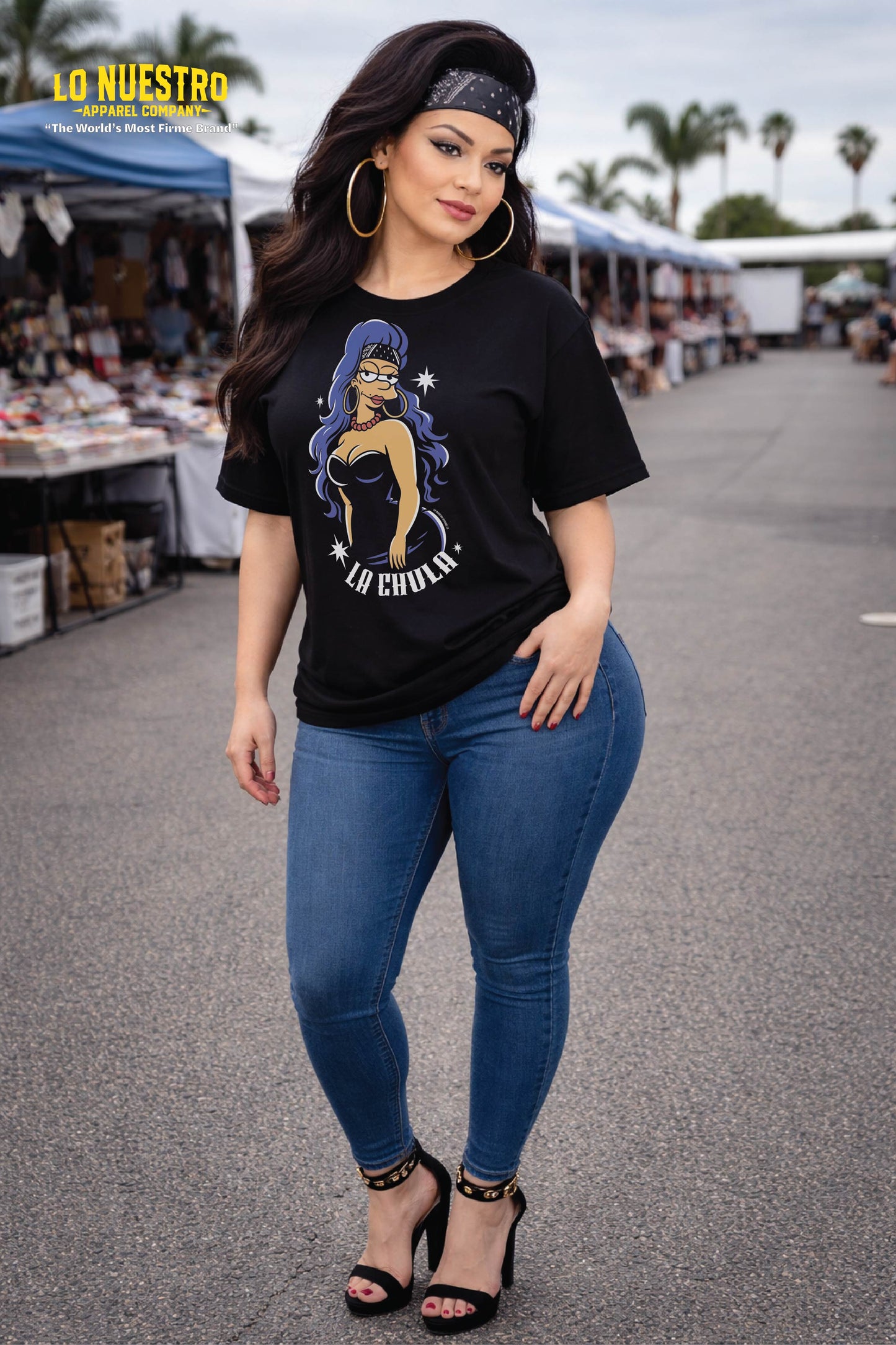 Latina model wearing La Chula graphic t-shirt at a swap meet, black relaxed fit streetwear tee with pin-up design