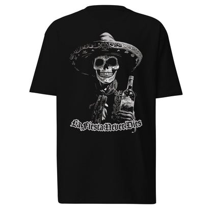 Black t-shirt laid on a white background, featuring a bold 'La Fiesta Never Dies' Dia de los Muertos design with a charro skeleton holding a bottle.