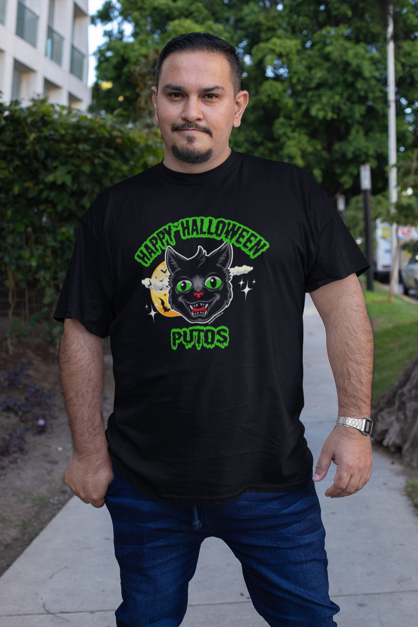 Man wearing Happy Halloween Putos Men's T-Shirt with black cat graphic while standing outside – Funny Halloween T-Shirt, Sarcastic Halloween Shirt, Men's Halloween Apparel.