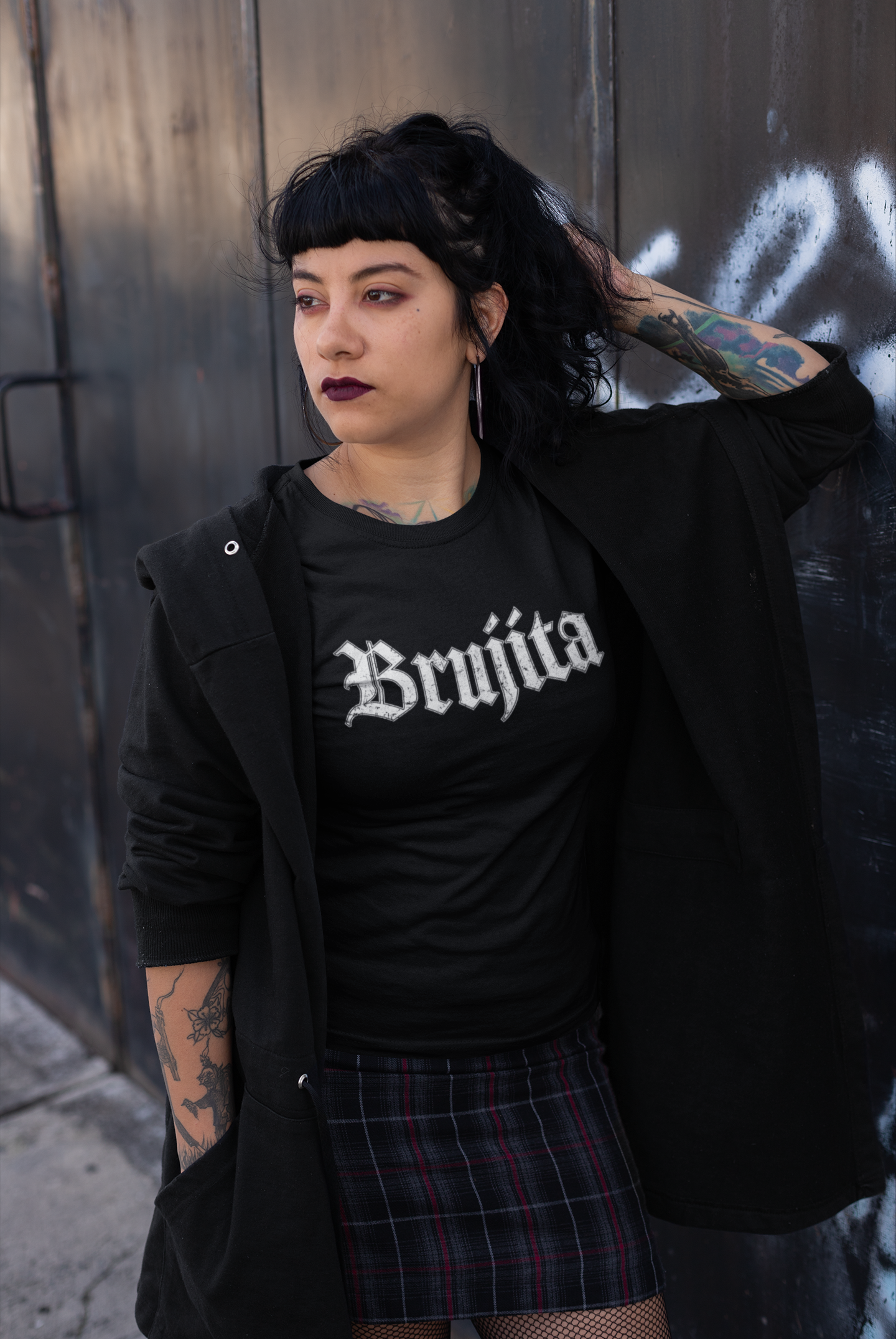 Woman wearing Brujita T-Shirt leaning against a wall – Modern witch vibes, gothic style