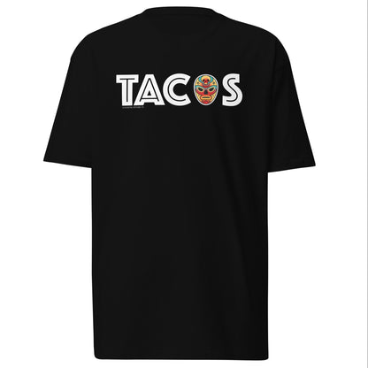 Black T-shirt with "TACOS" text and a colorful luchador mask replacing the letter "O." Mexican food and wrestling-inspired design for taco lovers.