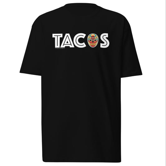 Black T-shirt with "TACOS" text and a colorful luchador mask replacing the letter "O." Mexican food and wrestling-inspired design for taco lovers.