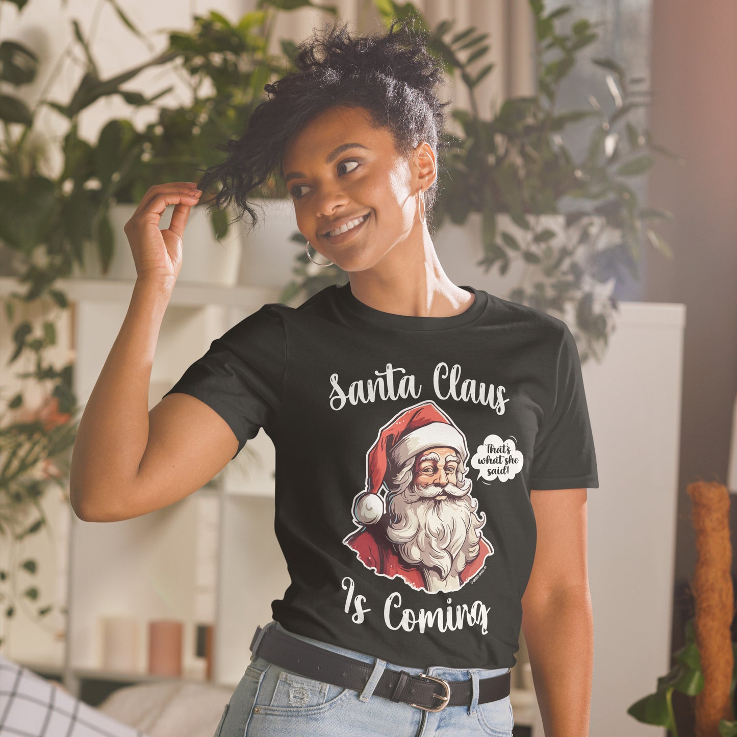 Woman smiling and wearing a "Santa Claus Is Coming" unisex shirt, bringing out the funny and festive spirit.