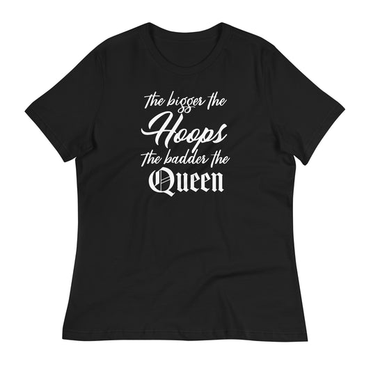 A black women’s t-shirt displayed flat with the bold white text 'The bigger the Hoops, the badder the Queen.' The text features a stylish mix of cursive and gothic fonts, emphasizing empowerment and confidence