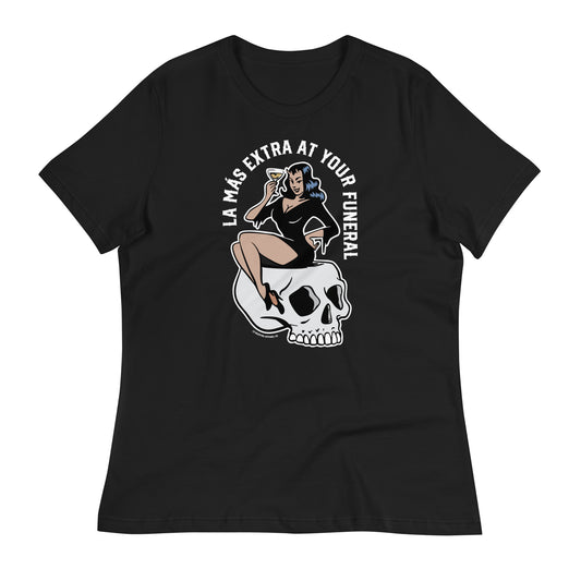 Black t-shirt laid flat showcasing the design of a pin-up woman on a skull holding a martini, surrounded by the text “La Más Extra at Your Funeral.