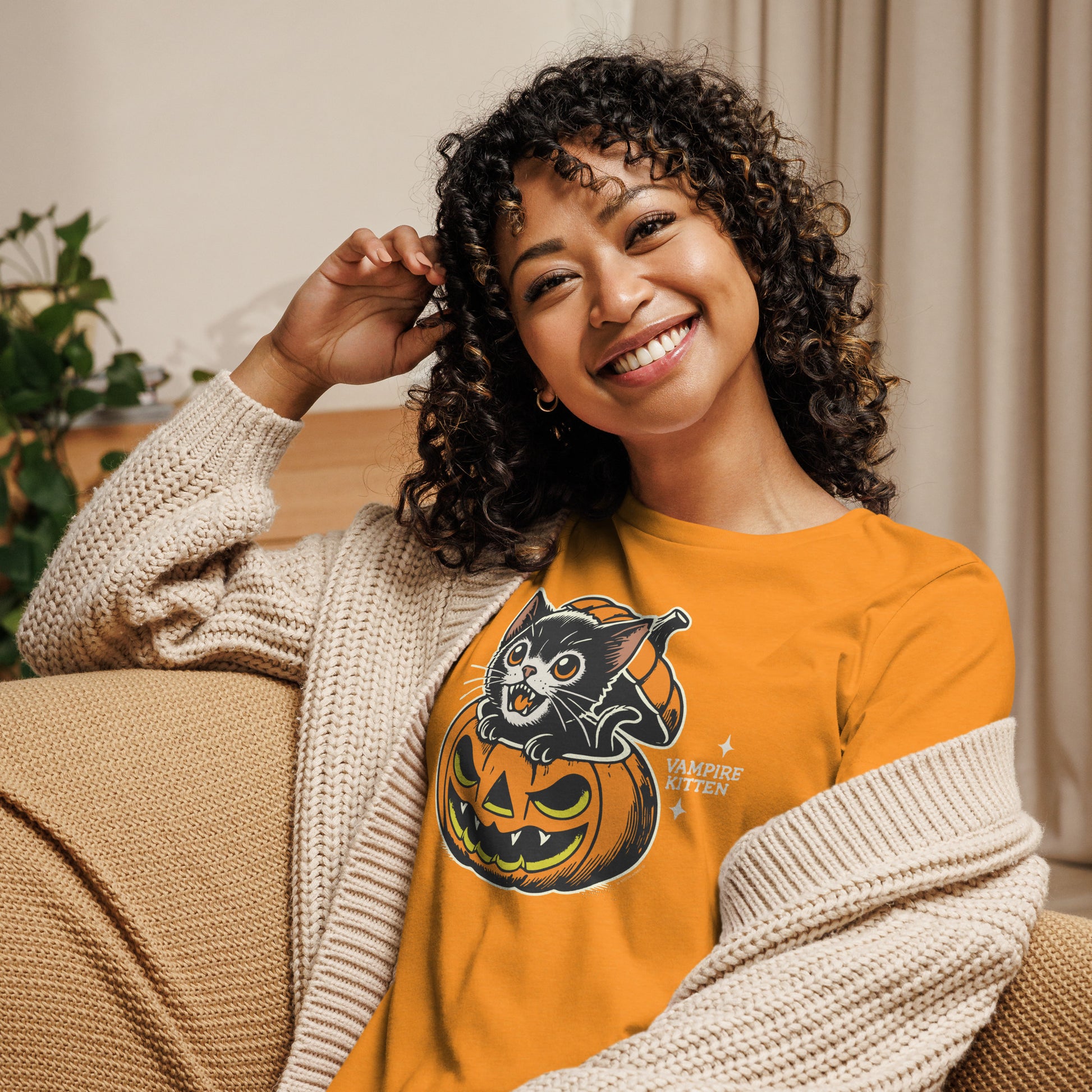 Woman wearing the Vampire Kitten Halloween T-Shirt in Heather Marmalade, showing off the fun and spooky kitten design, perfect for Halloween festivities.